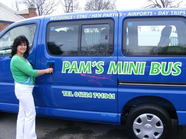 40226_103204476405235_7421427_n Pam standing in front of her blue mini bus